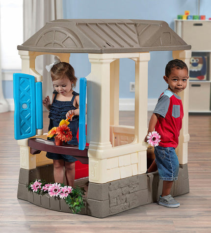 Step 2 Courtyard Cottage playhouse for children, outdoor toy with windows, door, and colorful exterior, ideal for outdoor play.