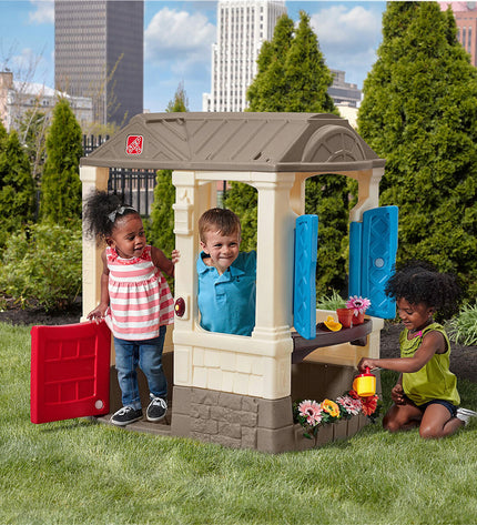 Step 2 Courtyard Cottage toy house for children, outdoor playhouse with windows and door, measuring 118x100x83 cm.