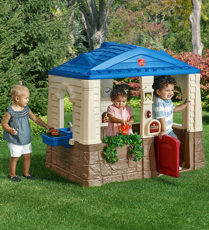 Step 2 Neat & Tidy Cottage toy house for kids, outdoor playhouse with windows and door in a colorful, child-friendly design.