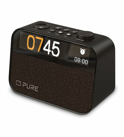 Pure MOMENT radio alarm clock showing digital display and control buttons, modern electronic audio device on a clean surface.
