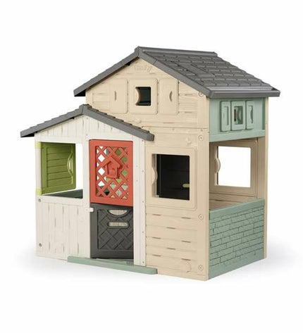Smoby Evo Friends children’s playhouse in outdoor setting, featuring colorful windows and door, measuring 162 x 164 cm.