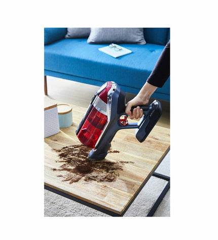 Rowenta X-Force Flex wireless steel vacuum cleaner with 0.9L capacity, 25.2V, 130W, shown in use on a hard floor.