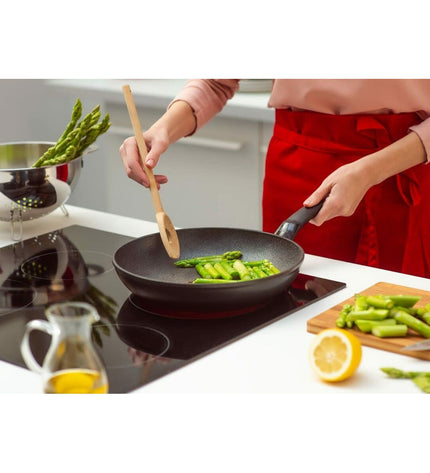Fissler ADAMAT CLASSIC black kitchen spatula with a sturdy handle and slotted design for cooking and stirring.