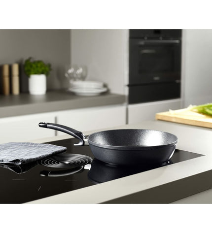 Fissler 28cm black aluminum pan for cooking and houseware, with sturdy handle and non-stick surface.