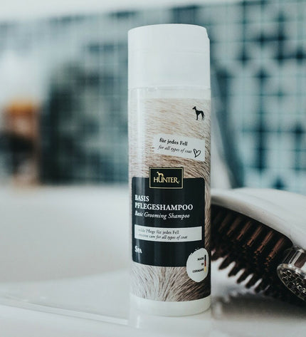 Hunter hondenkam shampoo for dogs, showing the bottle with label and grooming product packaging in a natural setting