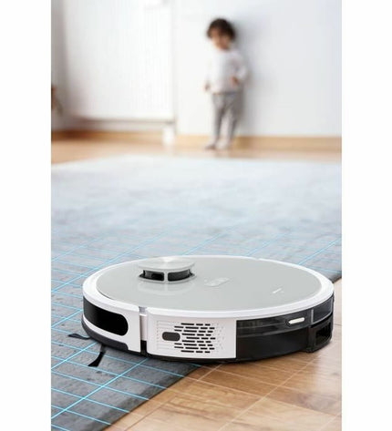 Medion Robot stofzuiger met 600 ml stofopvangbak, zichtbaar op een vloerkleed in een woonkamer.