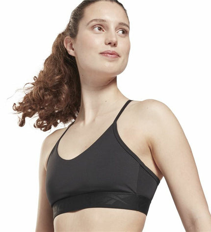 Reebok black strappy sports bra for cycling and outdoor activities, with supportive design and adjustable straps.