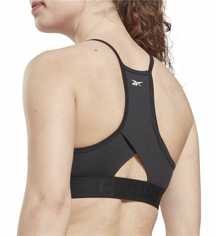 Reebok black sport bra with strappy design, suitable for outdoor and cycling activities, shown on a model.