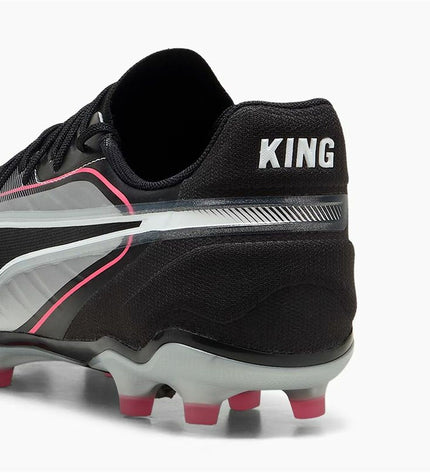 Adult Puma King Match football boots for outdoor soccer, showing black and white design with Puma logo and cleat studs.