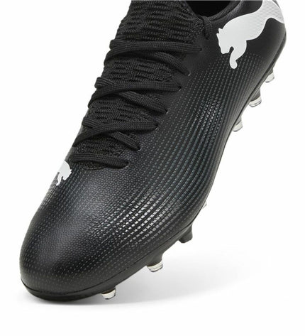 White and black Puma Future 7 Match MG adult football shoes with sporty design for outdoor soccer play.
