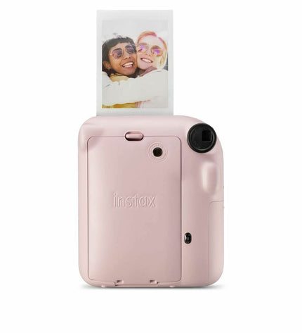 Pink Fujifilm Mini 12 instant camera with compact design, black accents, and lens ready for instant photos.