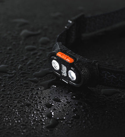 Nebo Einstein™ 1000 Flex LED headlamp for outdoor activities, showing adjustable straps and bright light in a camping setting.