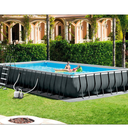 Intex 26378 removable backyard swimming pool, 975 x 132 x 488 cm, with water filled and set up outdoors in a garden setting.