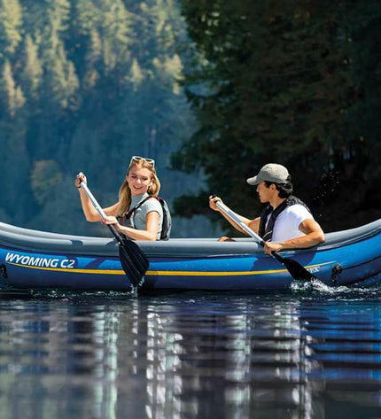 Inflatable kayak Intex Wyoming C2 in blue with seating and paddles, designed for outdoor watersport adventures.