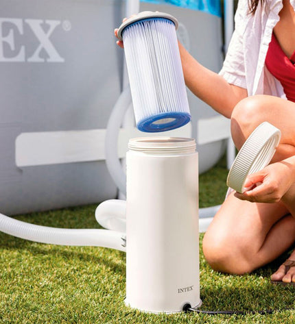 Intex zwembad behandelingsinstallatie for pool maintenance, shown with hoses and control unit in a garden setting.