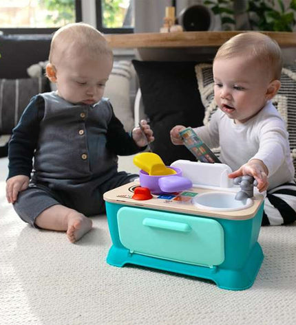 Hape speelgoedkeuken with colorful plastic stove, oven, and kitchen accessories for imaginative play and pretend cooking.