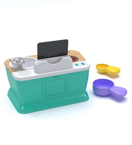 Hape speelgoedkeuken with colorful plastic stove, oven, and accessories for imaginative play in a child's playroom.