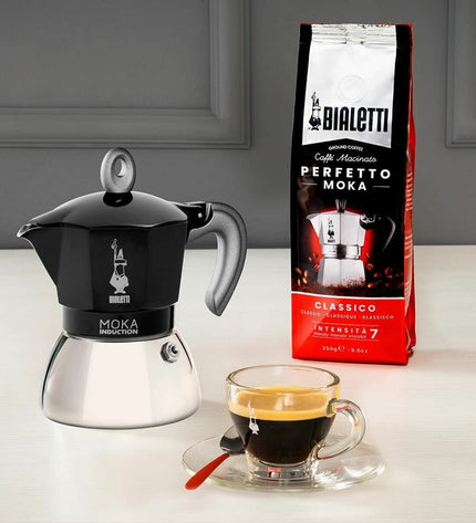 Black Bialetti Italian coffee pot made of aluminum, designed for brewing coffee on the stove in a classic kitchen setting.