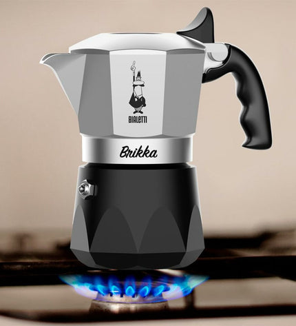 Bialetti Brikka Italian coffee pot in black aluminum with two cups, ideal for brewing rich espresso-style coffee.