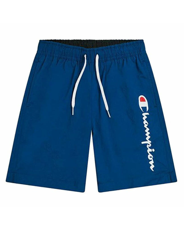 Child wearing a blue Champion swim set for kids, suitable for water sports and outdoor activities, on a sandy beach.