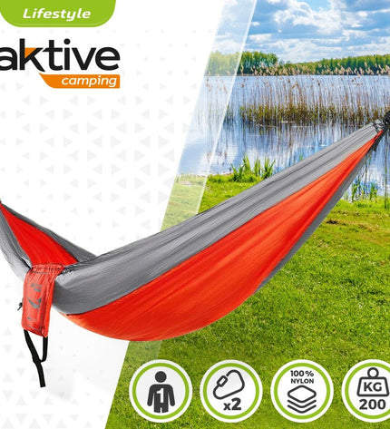 Aktive Hangmat 300x0.5x140 cm for outdoor camping and hiking, shown hanging between trees in a natural setting.