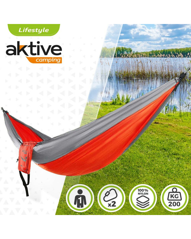 Aktive Hangmat 300x0.5x140 cm for outdoor camping and hiking, shown hanging between trees in a natural setting.