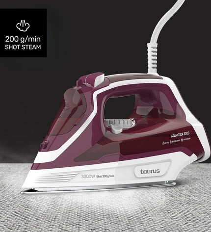 Taurus 918979000 steam iron with 3000W power, shown on a laundry table, featuring a sleek design and ergonomic handle.