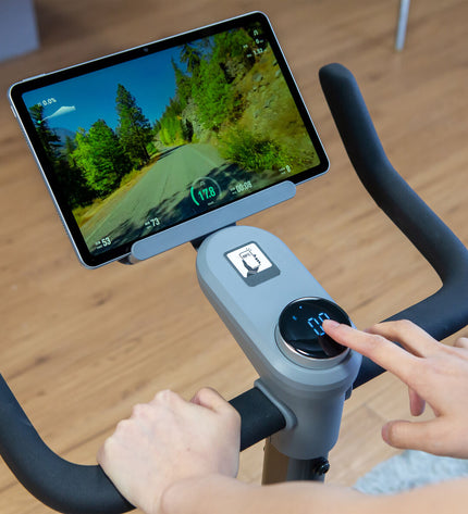 Refurbished Nexgim QB-C01 stationary exercise bike with Bluetooth 5.0, black frame, digital display, and adjustable seat.
