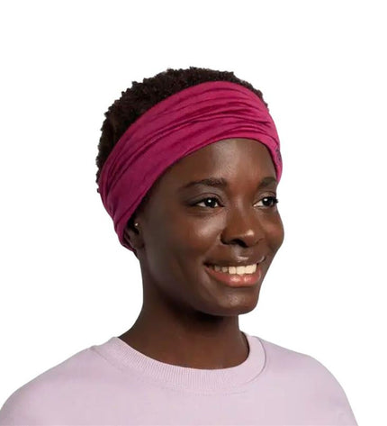 Buff Nekwarmer Buff Merino in lightweight magenta-brown, designed for outdoor activities like camping and hiking.