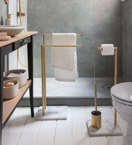 Andrea House toilet paper holder with brush stand in gold, bathroom accessory featuring a sleek design and functional storage.