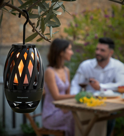 InnovaGoods wireless speakerphone with LED flame effect, outdoor garden decor, showcasing the device and glowing flame design.