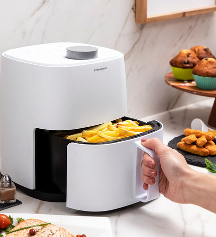 InnovaGoods Fryinn Lite 2000 air fryer, white compact kitchen appliance with 2-liter capacity and 1200W power, on a kitchen countertop.