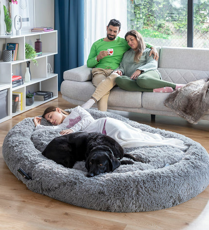 Large grey human dog bed by InnovaGoods with soft fabric and cushioned surface, designed for comfort and relaxation.