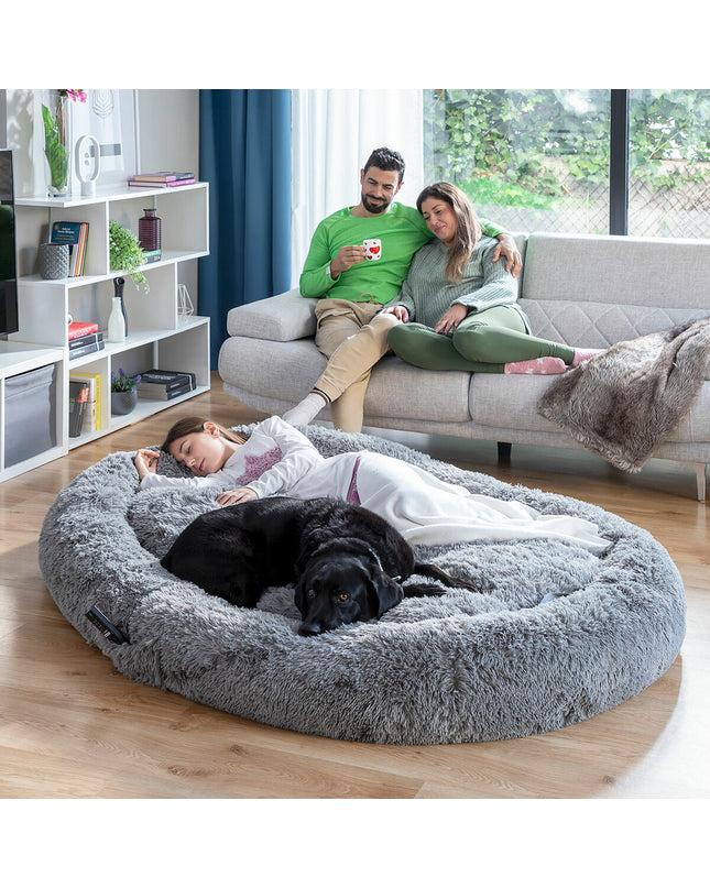 Large grey human dog bed by InnovaGoods with soft fabric and cushioned surface, designed for comfort and relaxation.