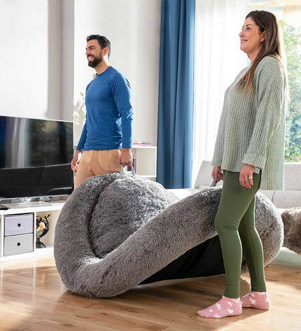 Large grey human dog bed by InnovaGoods, comfortable oversized furniture piece for relaxing or lounging.