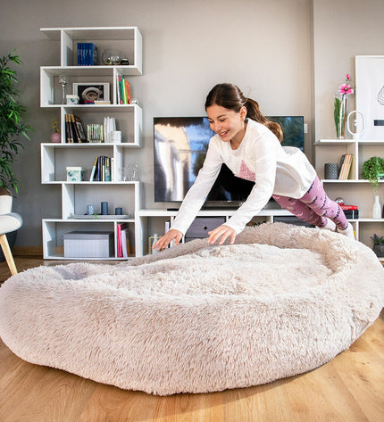 Beige human-sized dog bed by InnovaGoods with plush fabric and cushioned surface for comfortable relaxation.