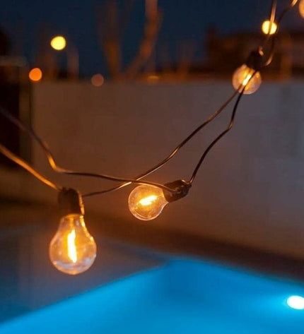 LED-lichtkrans New Garden Allegra 8m outdoor garden decoration with 10 white and black solar-powered lights on a garden setting