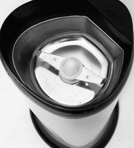 Orbegozo MO 3250 coffee grinder with 150W motor, black housing, showing the textured grinding burrs and control knob.