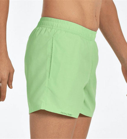 Green men's swim trunks by John Smith, Natales M for sports and watersports, shown on a model.