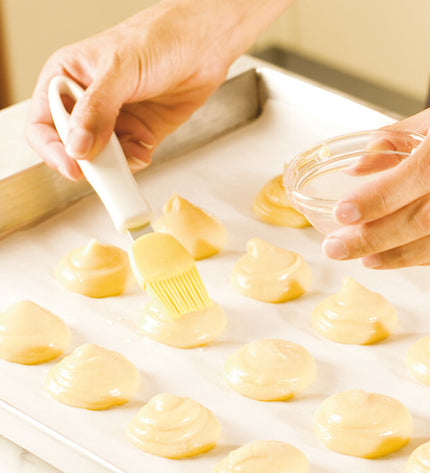 Yellow Tescoma Presto silicone kitchen brush for baking and cooking, with a comfortable handle and flexible silicone bristles.