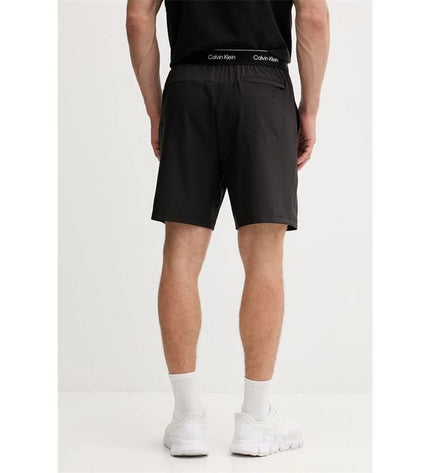 Black Calvin Klein men's woven swim trunks for sport and watersport activities, featuring a sleek, comfortable design.