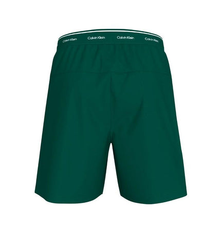Calvin Klein men's woven green swim trunks for sport and watersports, with a sporty design and adjustable waistband.