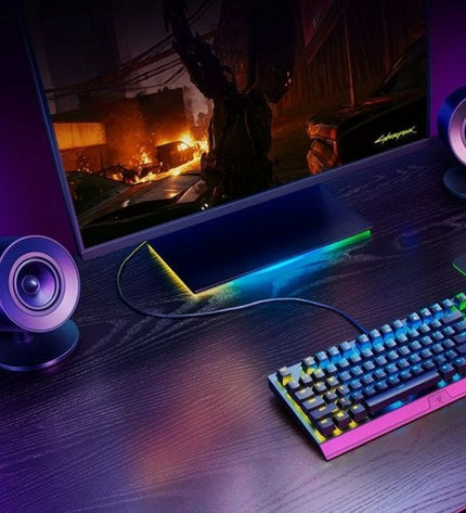 Razer Bluetooth portable speaker connected to a gaming console, compact design with buttons and LED indicators visible.