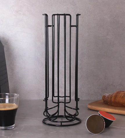 Quttin black iron coffee capsule organizer holding 12 capsules on kitchen countertop, compact 11.5 x 33 cm design.
