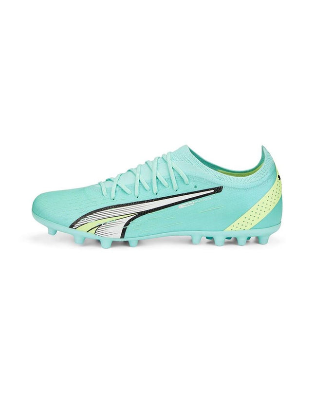 Puma adult football shoes in black with white accents, designed for outdoor soccer, featuring sleek athletic style.