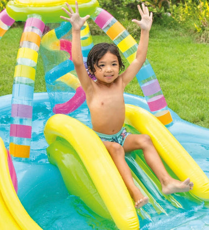 Two Intex inflatable children's rainbow pools with colorful exterior, measuring 295 x 109 x 191 cm, set up outdoors in a garden.