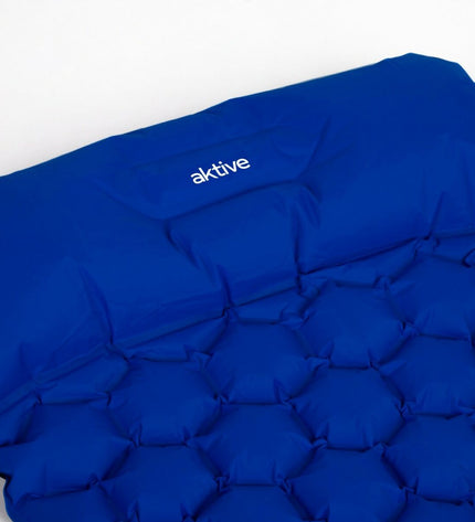 Aktive Mat Aktive TPU 185 x 15 x 57 cm for outdoor sports, camping, and hiking, shown rolled out on a grassy surface.