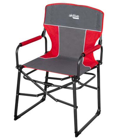 Two Aktive foldable camping chairs in black with armrests, set up outdoors on a grassy area.