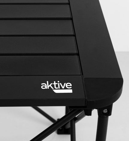 Two Aktive folding tables, 52 x 46 x 52 cm, suitable for outdoor camping and sports, shown stacked on a campsite.
