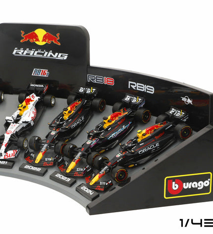 Set of four Red Bull Raceauto toy cars by BURAGO, detailed miniature vehicles in red and white with racing decals.